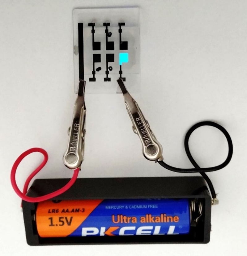 乾電池（1.5 V）1本で青色有機ELを光らせている写真