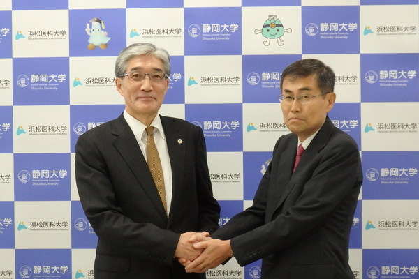 握手する今野浜松医科大学長（左側）と石井静岡大学長（右側）