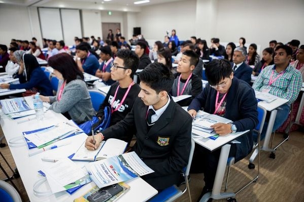High school students taking notes during the presentation on the Asia Bridge Program